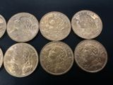 six different types of silver coins on a black surface