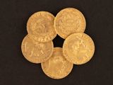five gold coins are arranged in a circle on a black surface
