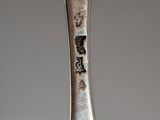 a silver spoon with writing on it sitting on a table