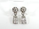 une paire de boucles d'oreilles en argent posées sur une surface blanche