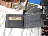 a wallet with a credit card in it sitting on a bed