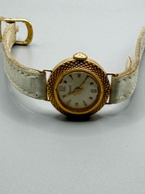 une montre posée sur une surface blanche