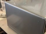 a silver microwave sitting on top of a white table