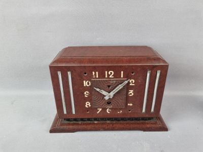 une petite horloge en bois posée sur une table