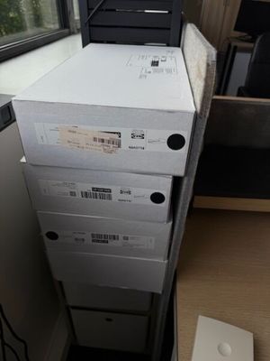 des boîtes empilées les unes sur les autres sur un bureau près d'une fenêtre