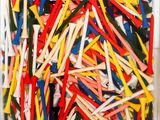 a close up of a box of assorted golf tees on a table
