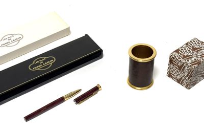 un stylo, une boîte et un pot à crayons posés sur une table