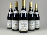 quatre bouteilles de vin sont alignées sur une table