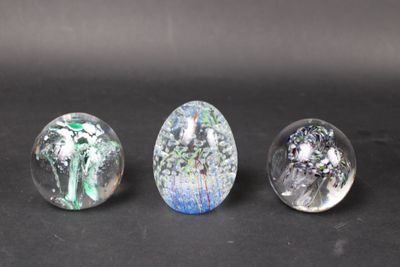 three glass marbles sitting on top of a table next to each other