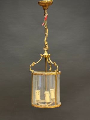 an antique brass and glass lantern hanging from a chain