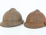 pair of old rusty helmets on a white background