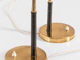 pair of black and brass table lamps on a white surface