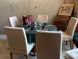 a dining room with a table and chairs and a painting on the wall