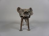 un petit animal en métal posé sur une surface blanche
