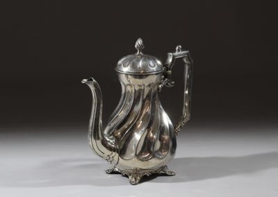 une théière ancienne en argent, dotée d'une anse, sur un fond blanc