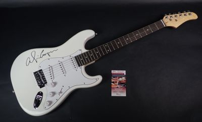 une guitare électrique blanche sur laquelle figure une photo dédicacée