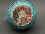 a close up of a blue vase on a table