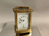 une horloge en or posée sur une table en verre