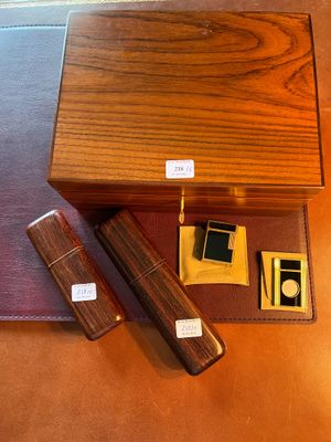 une boîte en bois avec, à côté, un stylo et un briquet