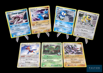 Plusieurs cartes Pokémon sont disposées en rangée sur un fond noir.