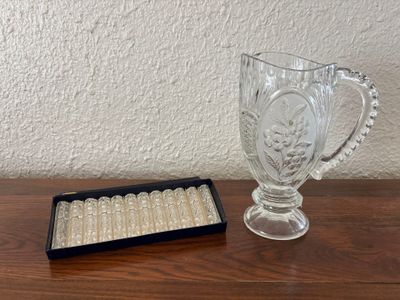 a glass cup and a box of cigarettes on a table