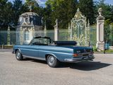a blue convertible car parked in front of a gate