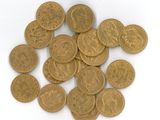 une pile de pièces d'or posée sur une surface blanche