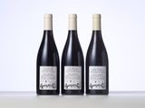 three bottles of wine sitting on top of a table next to each other