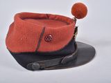 a red and black hat with a pom pom on top of it