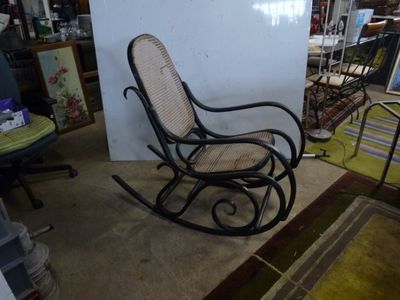 a rocking chair in a room with a rug on the floor
