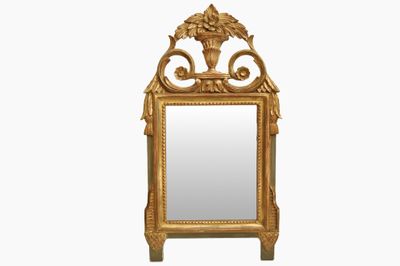 un miroir avec un cadre doré, sur lequel est posé un vase