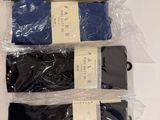 four pairs of men ' s socks are wrapped in plastic on a table
