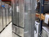 several refrigerators stacked on pallets in a large warehouse