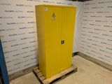 une photo d'une armoire jaune dans une pièce, avec une affiche accrochée au mur derrière elle