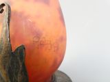 une statue représentant un chat assis sur un vase
