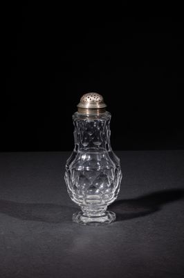 a small glass jar with a silver lid on a table