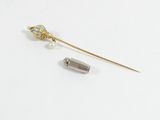 une image représentant une broche en or et perles, ornée d'une perle
