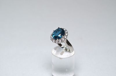 an image of a blue and white diamond ring on a clear surface