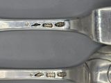 two spoons and a fork that are on a table