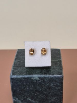 une paire de boucles d'oreilles en or posée sur un bloc de marbre