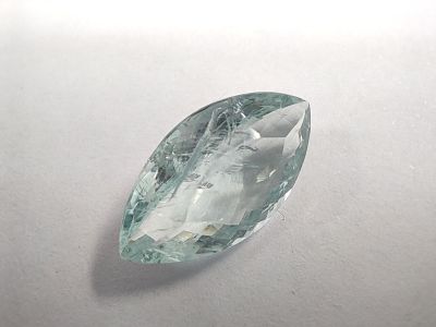 a close up of a green and white gemstone on a white surface
