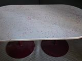 a white table with red legs and a white table top