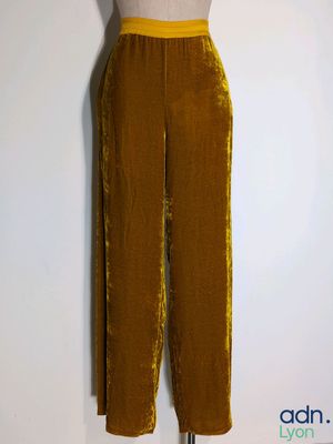 the mannequin is wearing a brown velvet pants and a white top