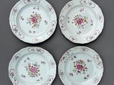 quatre assiettes à motifs floraux posées sur une table