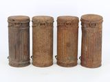 three old metal containers are lined up on a white surface