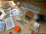 une table sur laquelle se trouvent de nombreux objets, notamment des stylos, des crayons, des ciseaux et un téléphone portable