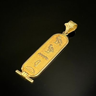 un gros plan d'un pendentif plaqué or sur un fond noir