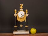 a clock and an apple sitting on a table