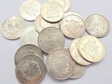 some silver coins on a white surface with a white background
