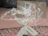 a pink blanket wrapped in plastic with a tag on it